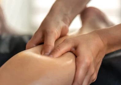 Close view of thumb work on calf trigger areas with oil. Controlled pressure supports myofascial release and restores lightness.