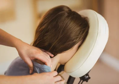 Young woman getting massage in chair in therapy room